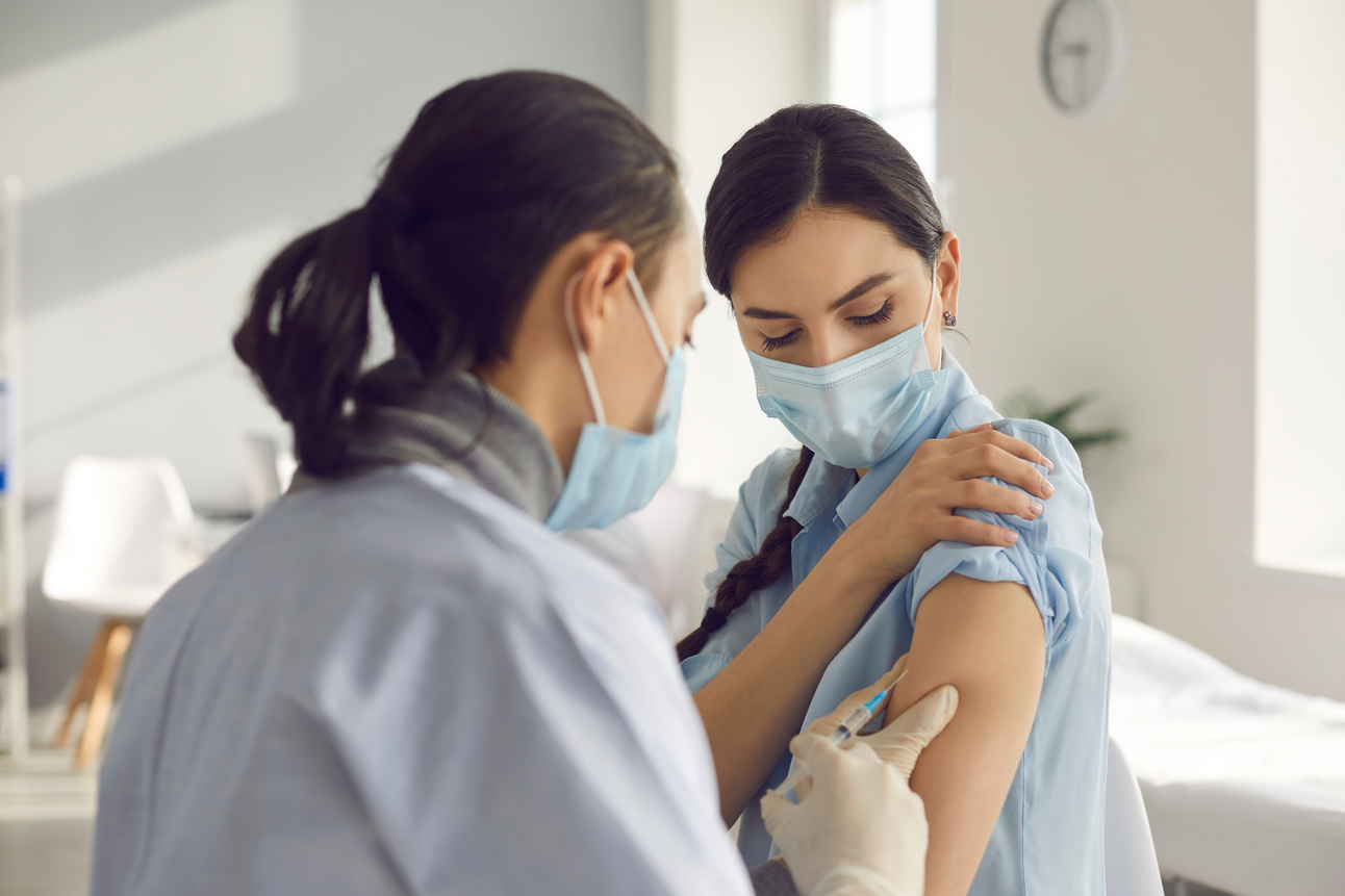 Young Woman Getting Antiviral Vaccine Injection during Seasonal Vaccination Campaign