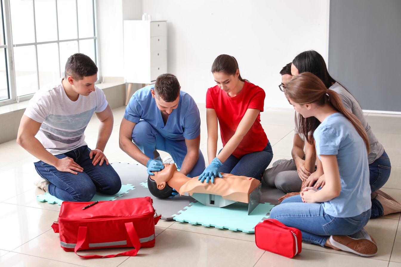 Instructors Demonstrating CPR on Mannequin at First Aid Training Course
