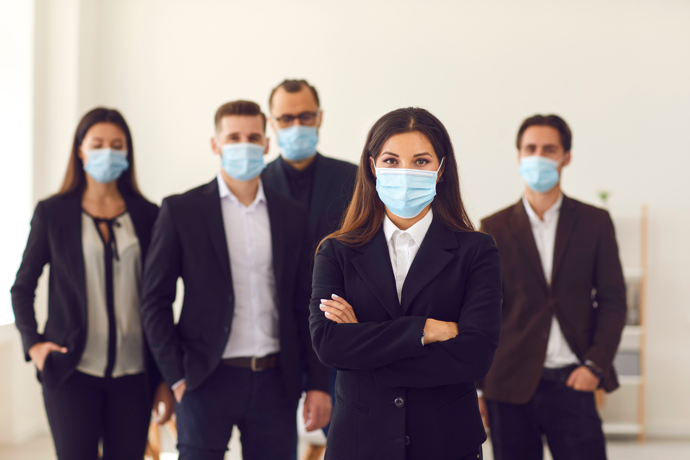 Responsible Young Company Manager with Group of Workers All Wearing Face Masks at Work